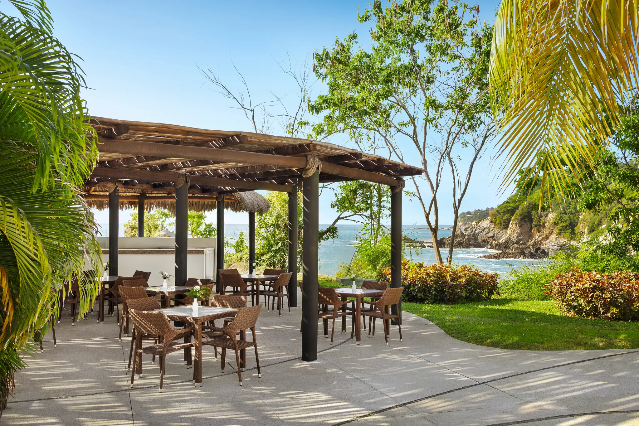 Barefoot Grill at Secrets Huatulco Resort & Spa featuring open-air seating, tropical surroundings, and ocean-view casual dining by the pool.