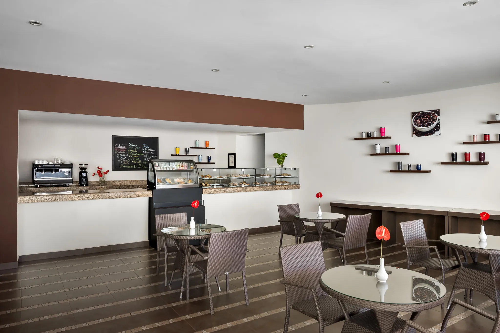 Coco Café at Secrets Huatulco Resort & Spa featuring a modern coffee bar, pastry display case, and cozy café seating.