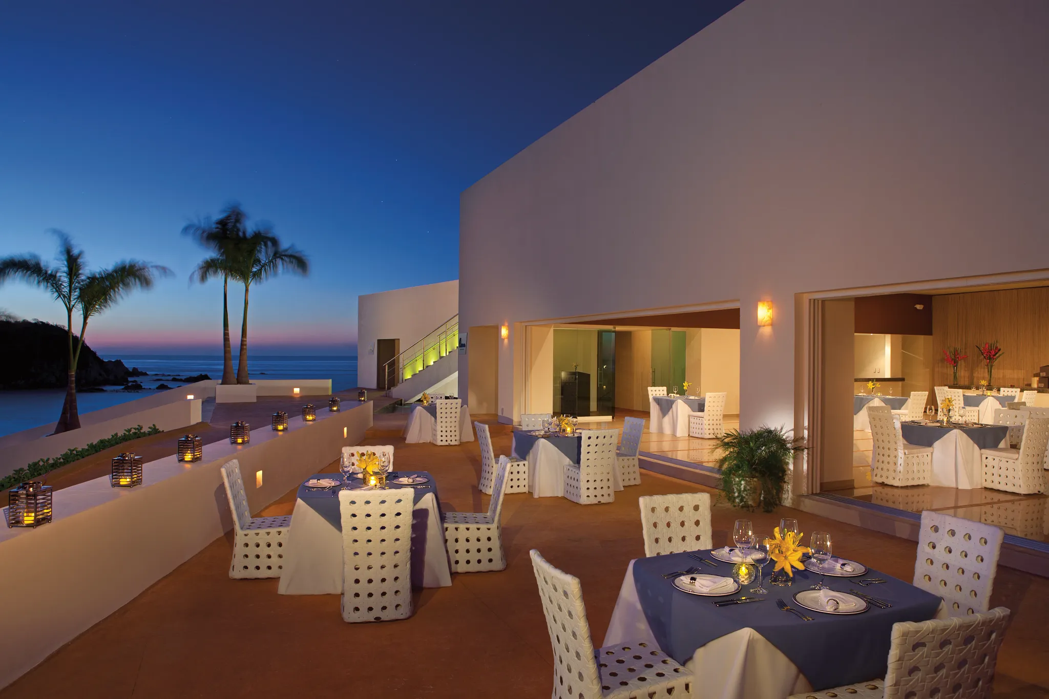 Oceana seafood restaurant at Secrets Huatulco Resort & Spa featuring elegant oceanfront terrace dining, candlelit tables, and sunset views.