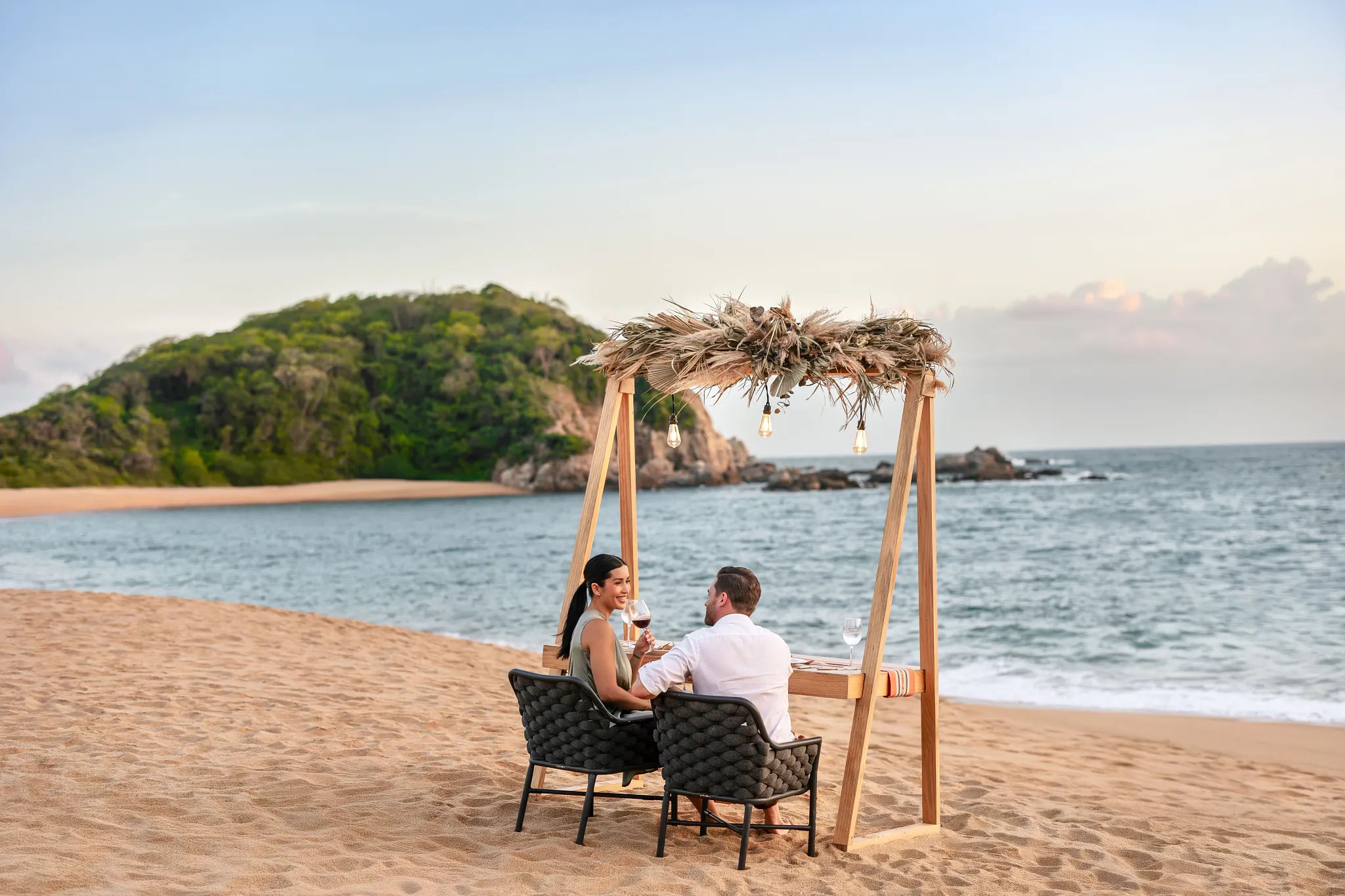 Couple enjoying private beachfront dining under a canopy at Secrets Huatulco Resort & Spa.