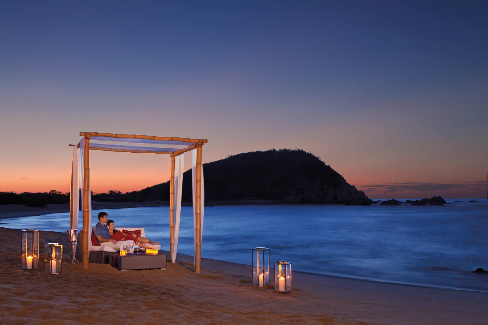 Romantic candlelit dinner on the beach at sunset at Secrets Huatulco Resort & Spa.