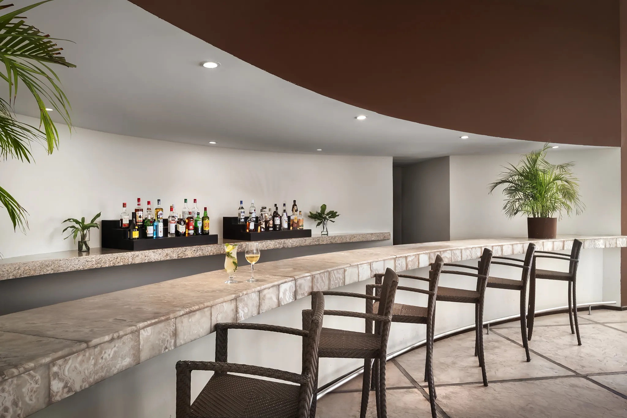 Showtime Theater Bar at Secrets Huatulco Resort & Spa featuring a curved marble bar, modern seating, and pre-show cocktail atmosphere.